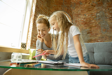 Image showing Teacher and little girl, or mom and daughter. Homeschooling concept