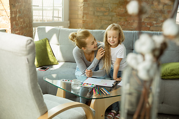 Image showing Teacher and little girl, or mom and daughter. Homeschooling concept