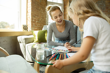 Image showing Teacher and little girl, or mom and daughter. Homeschooling concept