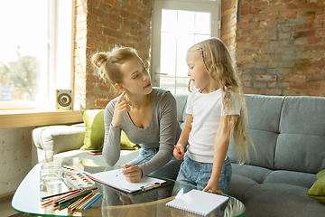 Image showing Teacher and little girl, or mom and daughter. Homeschooling concept