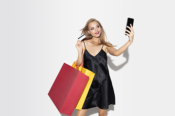 Image showing Young woman in dress shopping on white background