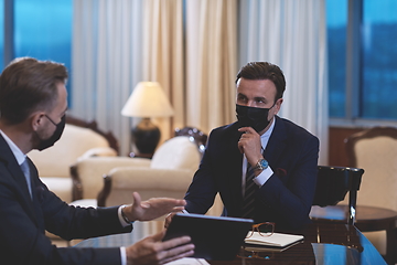 Image showing business people wearing crona virus protection face mask on meeting