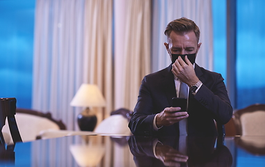 Image showing business man using smart phone at luxury office wearing face mask