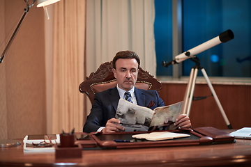 Image showing corporate business man at office reading magazine