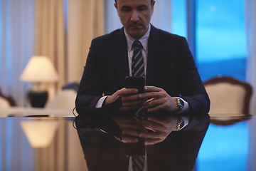 Image showing business man using smart phone at luxury office