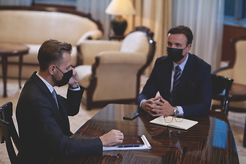 Image showing business people wearing crona virus protection face mask on meeting