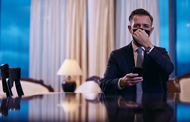 Image showing business man using smart phone at luxury office wearing face mask