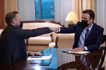 Image showing business people wearing face mask on meeting and handshake