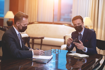 Image showing business people wearing crona virus protection face mask on meeting