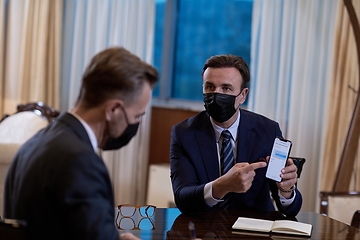 Image showing business people wearing crona virus protection face mask on meeting