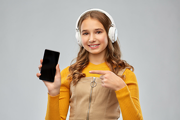 Image showing teenage girl in headphones showing smartphone