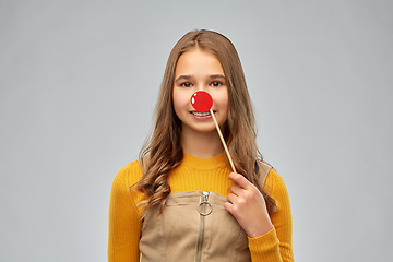 Image showing smiling teenage girl with red clown nose