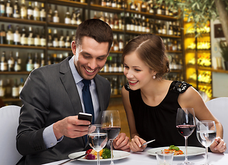 Image showing smiling couple eating main course at restaurant