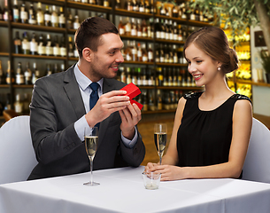 Image showing happy couple with gift box at restaurant