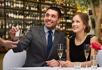 Image showing hsppy couple paying with credit card at restaurant