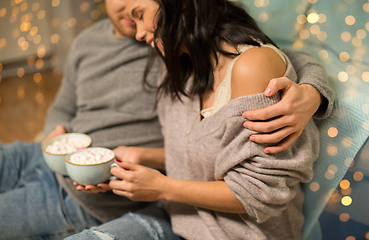 Image showing close up of couple with hot chocolate at home