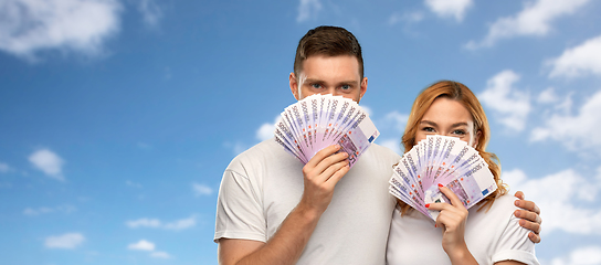 Image showing happy couple in white t-shirts with euro money