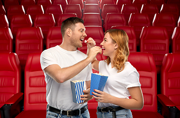 Image showing happy couple eating popcorn at movie theatre