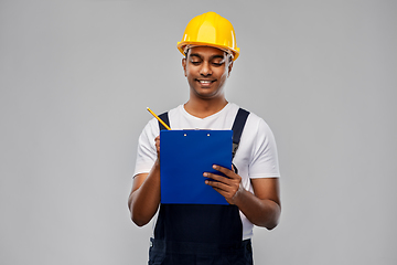 Image showing happy builder in helmet with clipboard and pencil