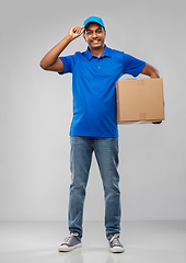 Image showing happy indian delivery man with parcel box in blue