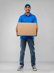 Image showing happy indian delivery man with parcel box in blue