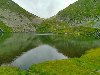 Image showing Clear mountain lake and crest behind