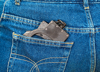 Image showing Black metal handcuffs in back jeans pocket