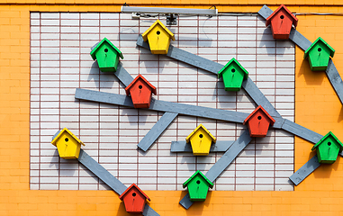 Image showing Colourful wooden birdhouses mounted on the brick wall