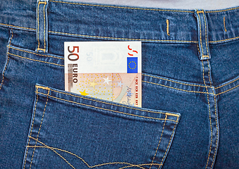Image showing Banknote 50 euro sticking out of the blue jeans pocket. Money fo