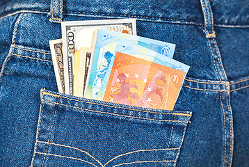 Image showing Euro and american currency, money in jeans pocket for travel and