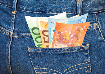 Image showing Euro banknotes sticking out of the blue jeans pocket. Money for 