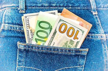 Image showing Euro and american currency, money in jeans pocket for travel and