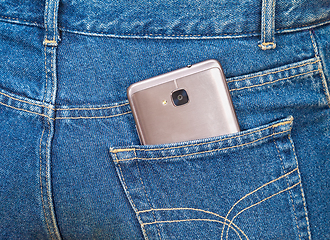 Image showing Smartphone sticking out of the back jeans pocket