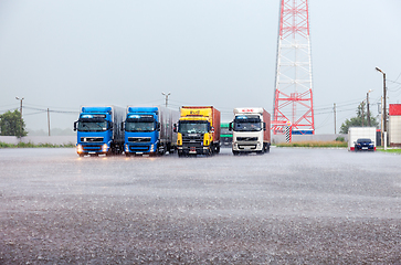 Image showing Truck trailers parked up at the parking lot in heavy rain