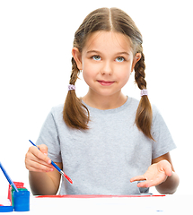 Image showing Little girl is painting with gouache