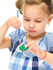 Image showing Little girl is painting with gouache