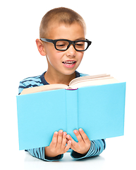 Image showing Little boy is reading a book