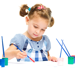 Image showing Little girl is painting with gouache