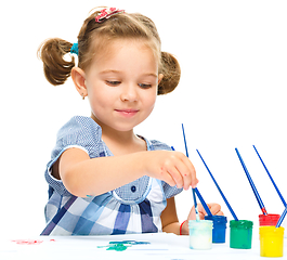 Image showing Little girl is painting with gouache