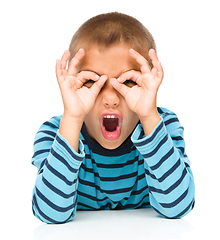 Image showing Astonished little boy is showing glasses gesture