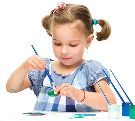 Image showing Little girl is painting with gouache