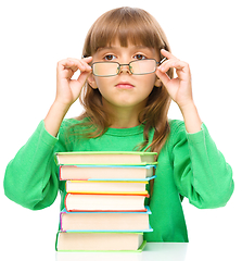 Image showing Little girl is reading a book