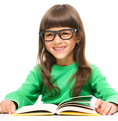 Image showing Little girl is reading a book