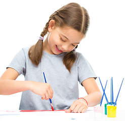 Image showing Little girl is painting with gouache