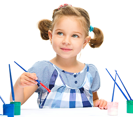 Image showing Little girl is painting with gouache