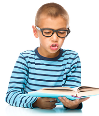 Image showing Little boy is reading a book