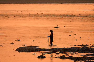 Image showing Asian Woman fishing in the river, silhouette at sunset