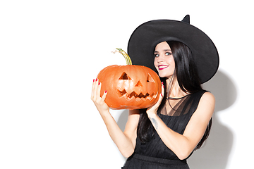 Image showing Young woman in hat and dress as a witch on white background