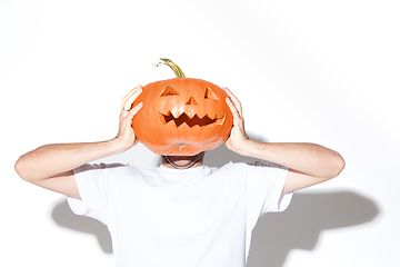 Image showing Young man holding pumpking on white background