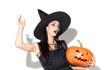 Image showing Young woman in hat and dress as a witch on white background